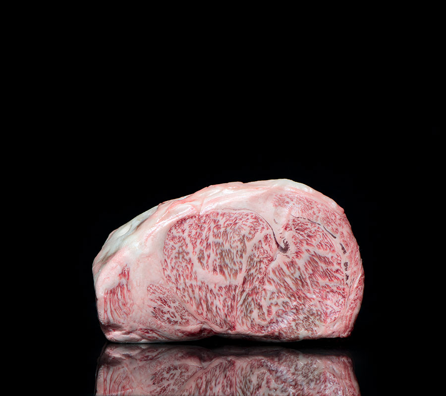 Entrecot de Wagyu Miyazaki beef A-5, pieza de lomo bajo cruda con el marmoleado del corte a la vista sobre fondo negro