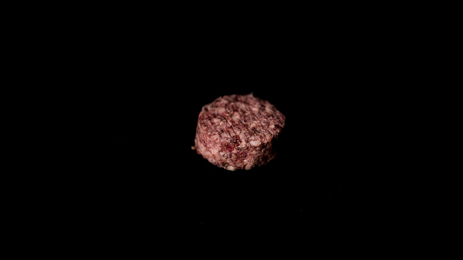 Hamburguesa de Novillo Angus, hamburguesa cruda de picado fino sobre fondo negro